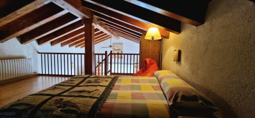 Habitación doble de lujo con balcón en Hotel Mas D'En Roqueta, con vigas de madera, tonos terracota y vistas al campo