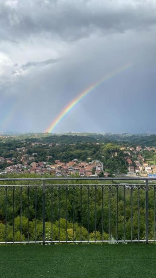 Rainbow over Ceccano valley view from Torre dei Venti balcony with lush greenery and town below
