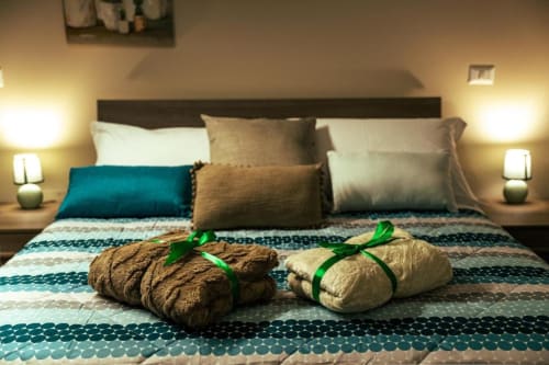 Grecale Deluxe Room at Torre dei Venti B&B in Ceccano with rolled towels, decorative pillows, and warm lighting.