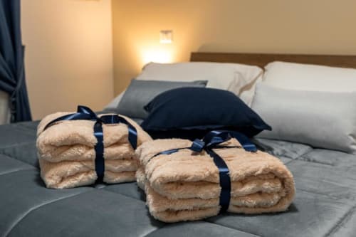 Fluffy towels tied with navy ribbon on bed in Mistral Room at Torre dei Venti B&B, Ceccano