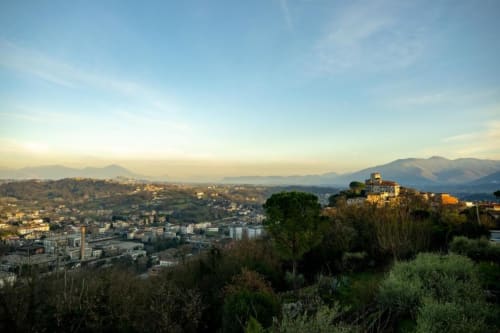 Torre dei Venti in Ceccano, Italy: hillside medieval tower and valley landscape with mountains at sunset