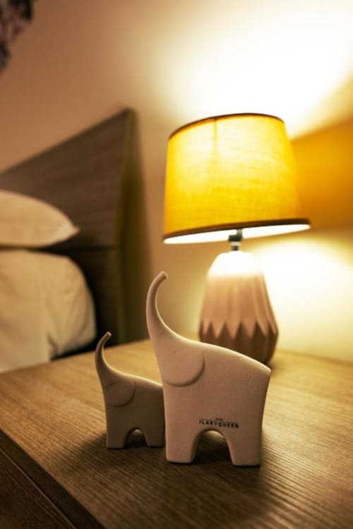 Eleganti statuette di elefante bianco accanto a una lampada da tavolo gialla nella Stanza Libeccio di Torre dei Venti, Ceccano