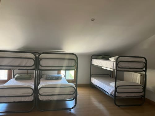 Habitación compartida en Posada de Ollo con cuatro literas y piso de madera