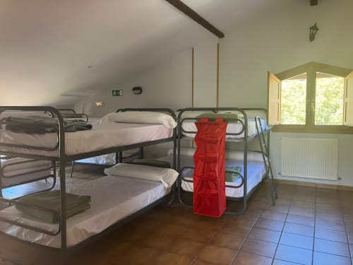 San Donato dormitory room at Posada de Ollo with bunk beds and shared bathroom facilities