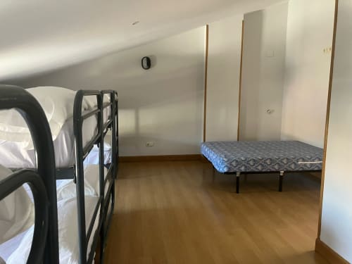 Attic room at Posada de Ollo with bunk beds and single bed on wooden floor