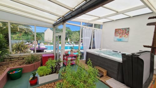 Spa y jardín en Domaine De Millox con jacuzzi, plantas y vistas a la piscina en Saint-André-de-Seignanx