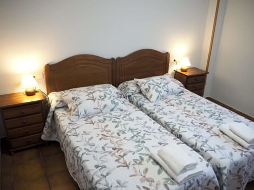 Txurregui double bedroom at Posada de Ollo with wooden headboard, twin beds, nightstands, and warm lighting