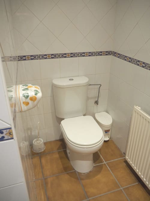 Private bathroom in Txurregui room at Posada de Ollo hotel, Spain, with toilet, sink, and tiled walls