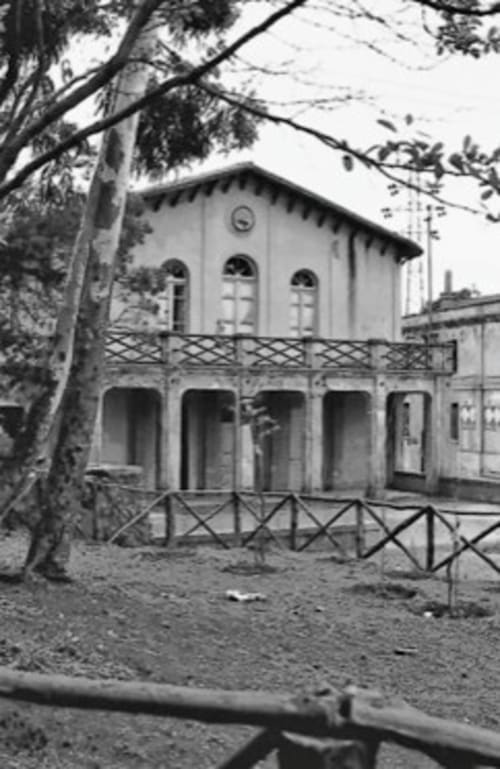 Affascinante facciata storica dell'Albergo Al Cinghiale di Guspini, con finestre ad arco e balconate in ferro battuto