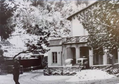 Hotel rustico innevato con ingresso ad arco e alberi sempreverdi dell'Albergo Al Cinghiale a Guspini