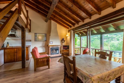 Apartamento Sebrango en Los Picos de Redo con vigas de madera, chimenea, comedor y vistas a la montaña desde la terraza