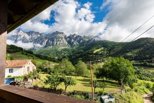 Vista del jardín del apartamento Sebrango con vistas a frondoso valle y montañas cerca de Camaleño, España