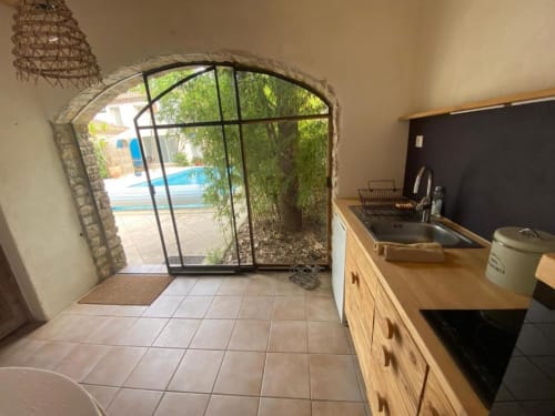 Cuisine avec vue sur la terrasse, la piscine et le jardin du Patio aux Oiseaux à La Ciotat
