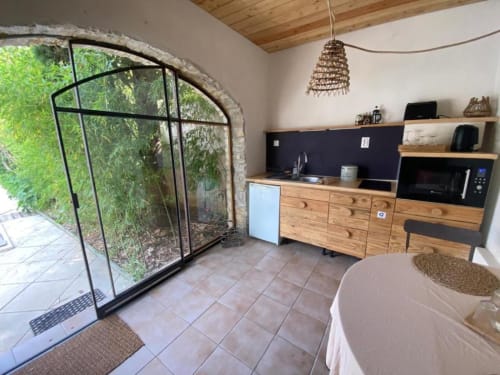 Kitchenette moderne avec placards en bois et accès à la terrasse du jardin, chambre La Mouette Rieuse, Le Patio aux Oiseaux, La Ciotat