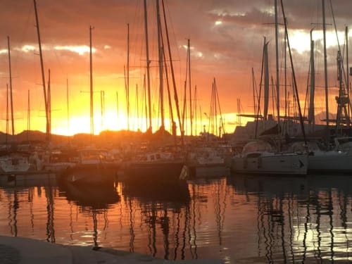 Voiliers amarrés au coucher de soleil dans le port de La Ciotat, avec des reflets dorés sur l'eau calme