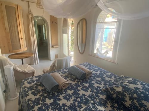 Chambre lumineuse à La Mouette Rieuse au Patio aux Oiseaux, La Ciotat, avec lit à motifs, serviettes roulées, miroirs et