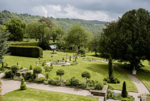 Gepflegte Gärten der Florence Nightingale Suites mit Brunnen, Rasen und Bäumen in Holloway, Derbyshire
