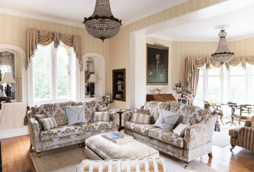 Elegantes Wohnzimmer in den Florence Nightingale Suites in Derbyshire mit cremefarbener Einrichtung, gemusterten Sofas und Kristall