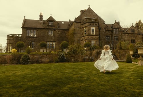 Braut im weißen Kleid, die sich auf dem Gelände von Florence Nightingale Suites, einem Steinherrenhaus-Hotel in Holloway, Derbyshire, dreht