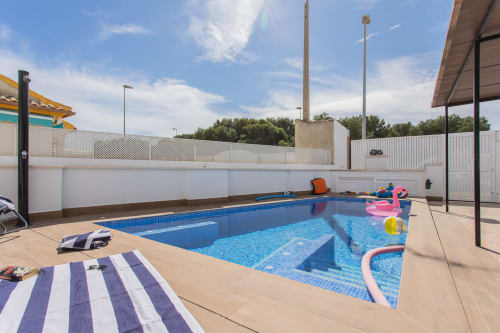 Piscina privada con azulejos azules y tumbonas en la villa Haus Holiday Homes en San Pedro del Pinatar, España