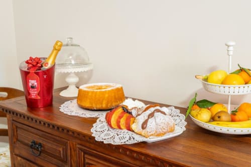 Elegante colazione al Torre dei Venti B&B Ceccano: pasticcini, torta, champagne e agrumi freschi su tavolo in legno