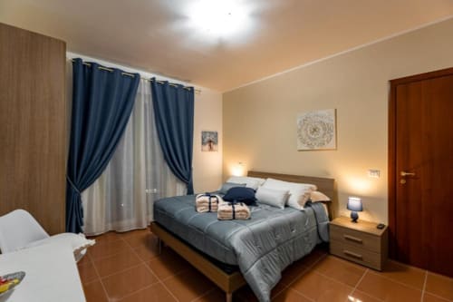 Camera Mistral a Torre dei Venti B&B a Ceccano con letto matrimoniale, tende blu, vista sul giardino e comfort moderni.
