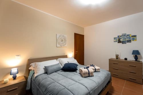 Mistral Room at Torre dei Venti B&B in Ceccano featuring queen bed with gray bedding, wooden furniture, and garden view
