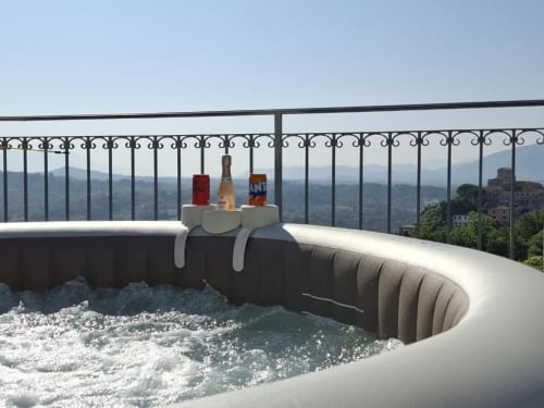 Vasca idromassaggio con acqua effervescente e bottiglie di vino a Torre dei Venti, con vista sulla campagna e le montagne di Ceccano
