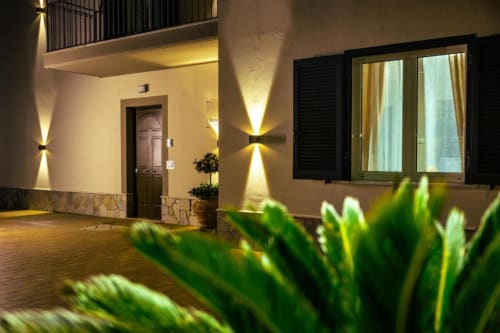 Vista notturna esterna della Torre dei Venti B&B a Ceccano, Italia, con illuminazione calda sulla facciata e porta d'ingresso