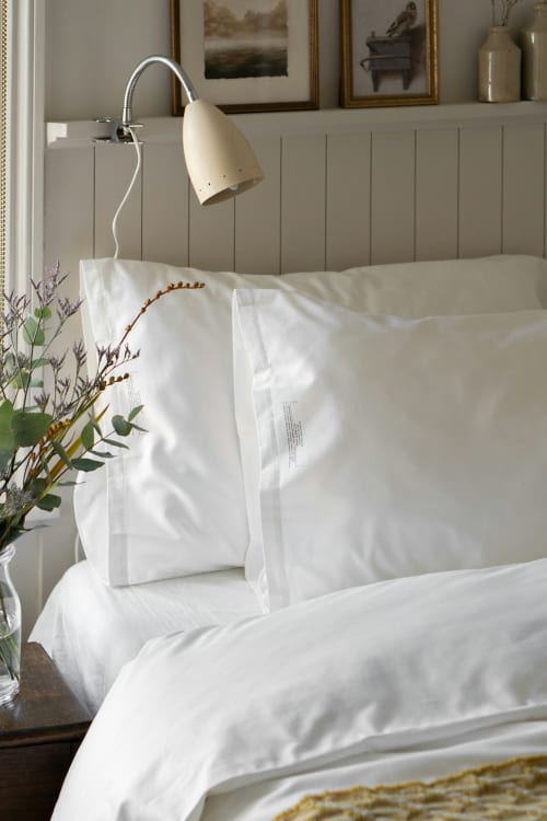 Biancheria da letto elegante e cuscini bianchi presso Borgo Luce, un affascinante bed and breakfast a Francavilla Marittima, Italia