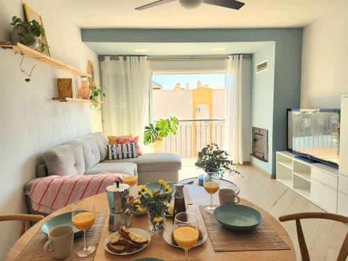 Luminoso apartamento moderno con sala de estar, mesa de comedor, sofá y vista a la terraza de Águilas, España