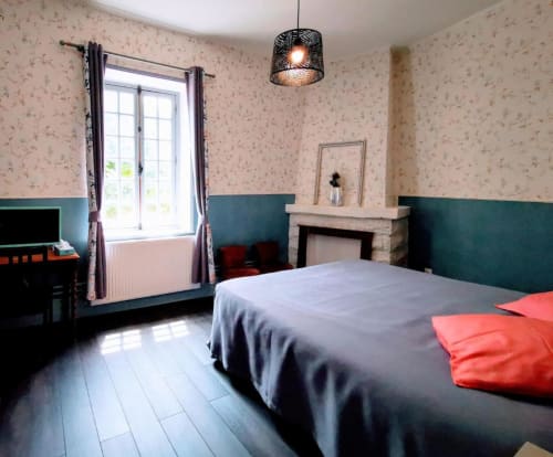 Chambre Le Coin au Gîte Le Coin des Artistes avec vue sur le jardin, lit, cheminée et lambris bleu-vert