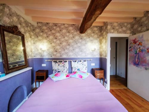 Chambre charmante du Coin des Artistes avec literie rose, papier peint floral et murs bleus