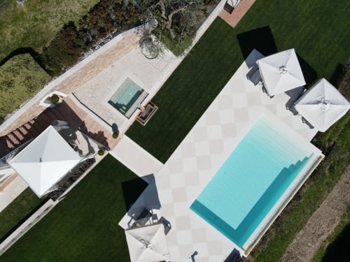 Vista aerea della Le Selve Hilltop Pool Villa a Toscolano Maderno con piscina privata turchese, ombrelloni bianchi e giardini curati