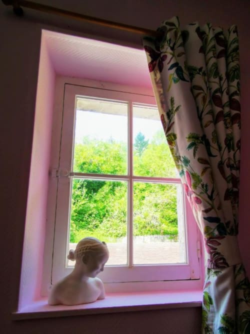 Coin fenêtre aux lumières roses chez Le Coin des Artistes, vue sur le jardin luxuriant, chambre Nymphéas