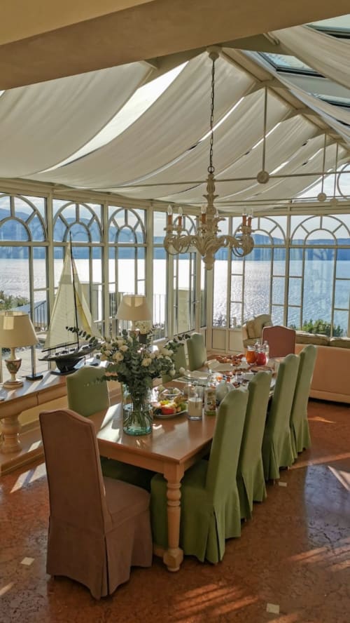 Elegante sala da pranzo con vista sul lago presso la villa I Wish Italy a Toscolano Maderno, con lampadario e soffitto drappeggiato