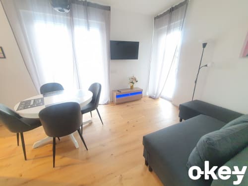 Soggiorno moderno ad Bari con area living, TV a schermo piatto, parquet e finestre luminose con vista sul mare