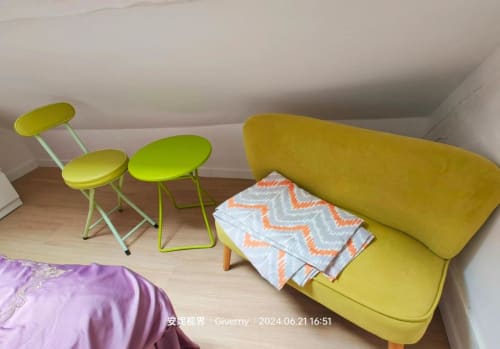 Canapé jaune et fauteuils dans la chambre Grenier de Le Coin des Artistes, gîte français