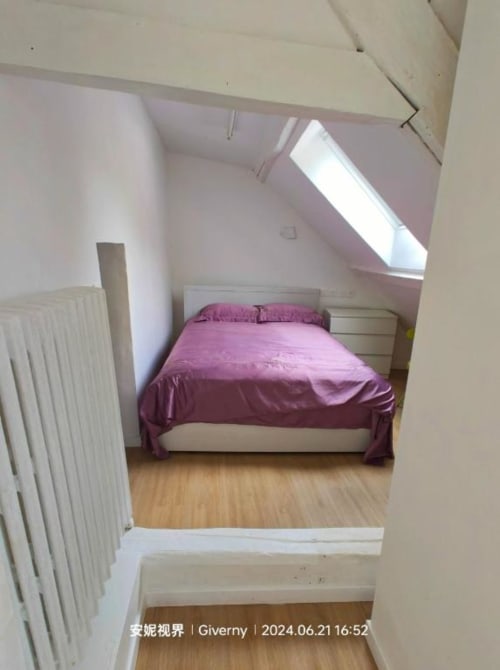 Chambre douillette sous les combles au Coin des Artistes avec literie violette, lucarne, radiateur blanc et parquet