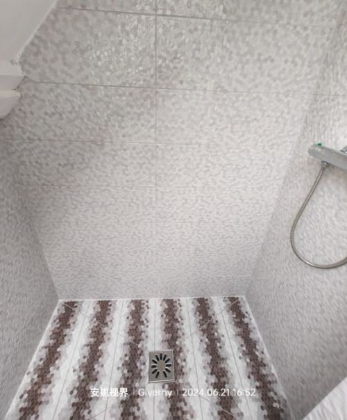 Salle de bains moderne avec douche et carrelage blanc et marron à Le Coin des Artistes, gîte français