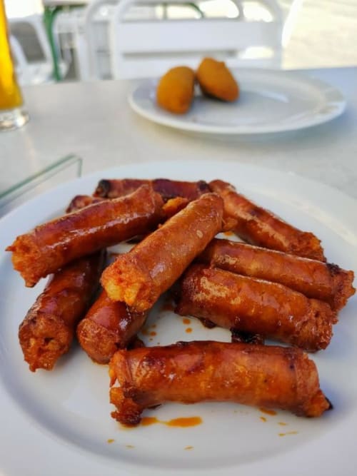 Crispy fried pastries on white plate at Posada de Ollo hotel in Ollo, Spain