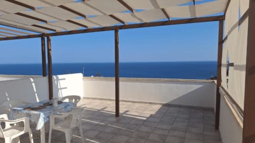 Terrazza panoramica Santa Cesarea Vacanze con pergolato, vista mare e arredo lounge bianco fronte Mediterraneo.