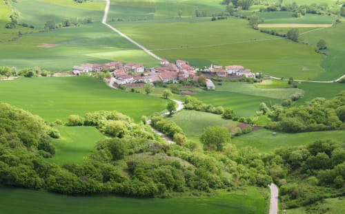 Aerial view of Posada de Ollo hotel nestled in green countryside valleys of Ollo, Spain