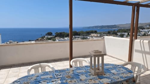 Terrazza sul tetto di Santa Cesarea Vacanze con vista sul Mare Adriatico, tavolo da pranzo e città costiera sottostante