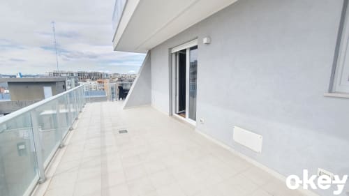 Terrazza di moderno appartamento fronte mare a Bari con vista sul mare, balaustra in vetro e porte scorrevoli