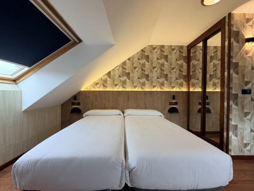 Moderno dormitorio doble en Hotel Puerto De Candás con tragaluces, panelado de madera y vistas al mar desde Candás, Asturias