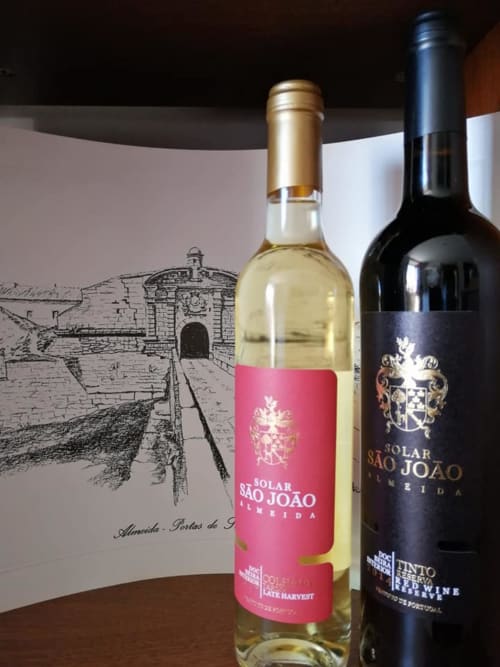 Solar São João wines displayed with historic fortress engraving at Portuguese wine estate