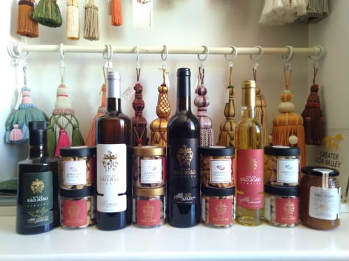 Solar de São João wine collection and decorative tassel display on shelf