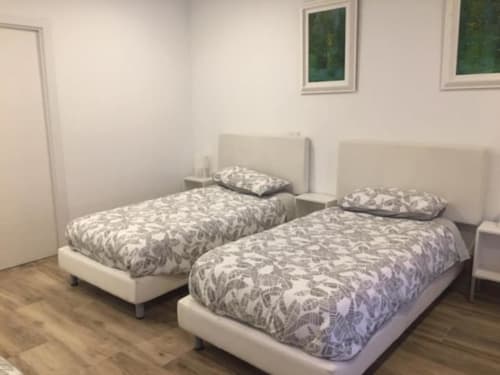 Two single beds with patterned bedding in a bright hotel room at Hotel Skyline, Alcorcón, with wooden flooring and cream