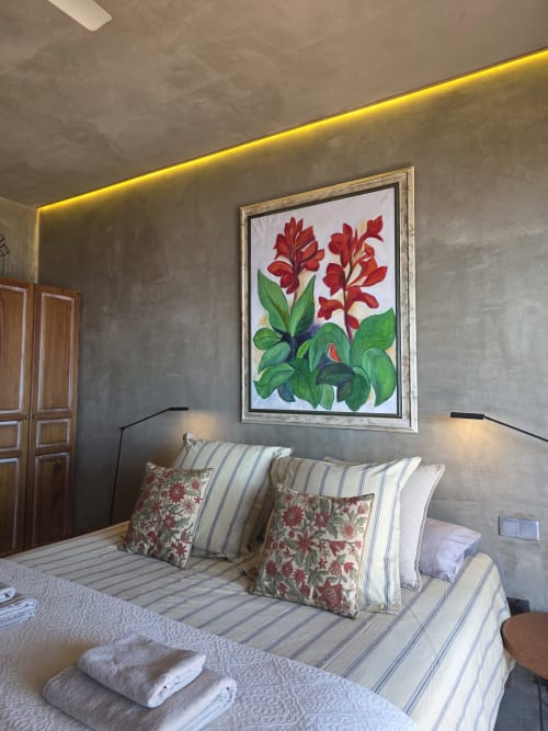 Quarto nas Les Terrasses Les Suites em Calheta com cama, roupa de cama listrada, almofadas florais e obra de arte com flores vermelhas em cinza